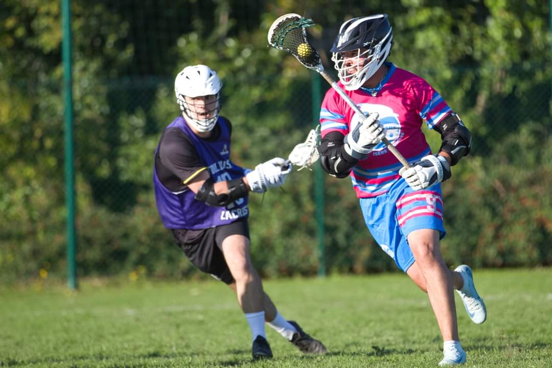 Action de lacrosse en Isère avec un joueur en mouvement.